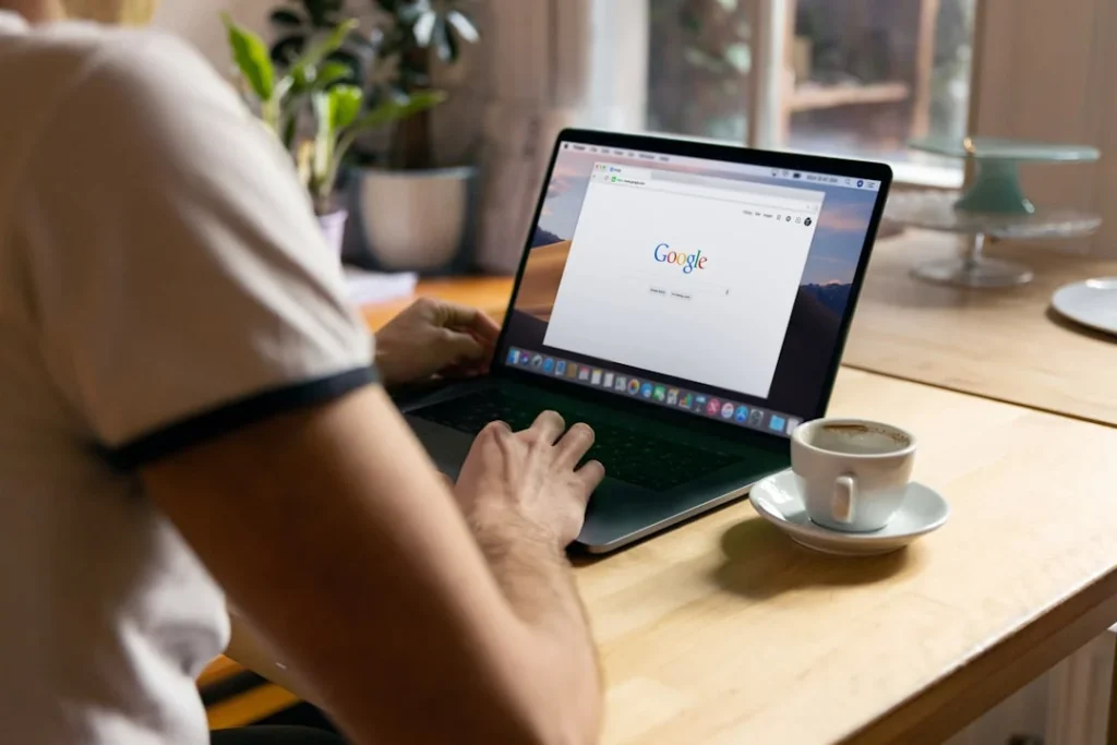 Person sucht am Laptop bei Google, Symbolbild für die Google-Suche mit AI Overviews